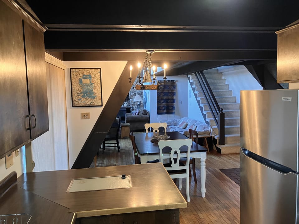 Charming open-plan living space with full kitchen and cozy dining area.