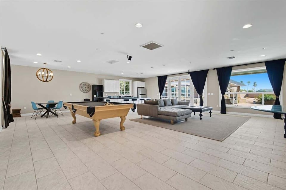 Casita: Open living area with designer furnishings, smart TV, pool table, and a dining area with seating for 4 guests.