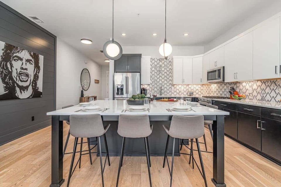 The fully equipped modern kitchen is stocked with all culinary essentials, stainless-steel appliances, and breakfast bar seating.