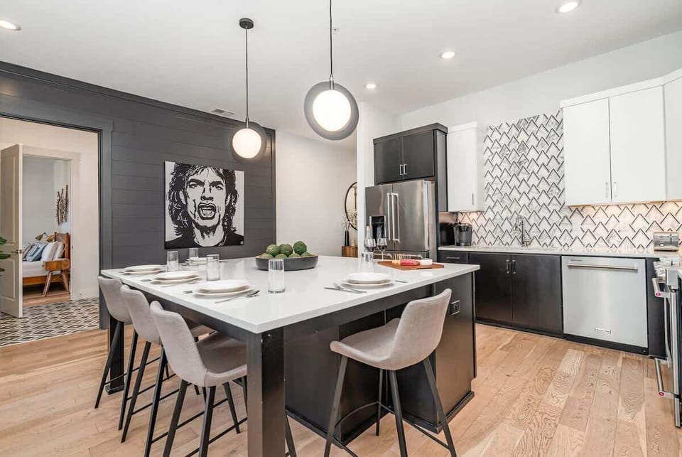 The fully equipped modern kitchen is stocked with all culinary essentials, stainless-steel appliances, and breakfast bar seating.