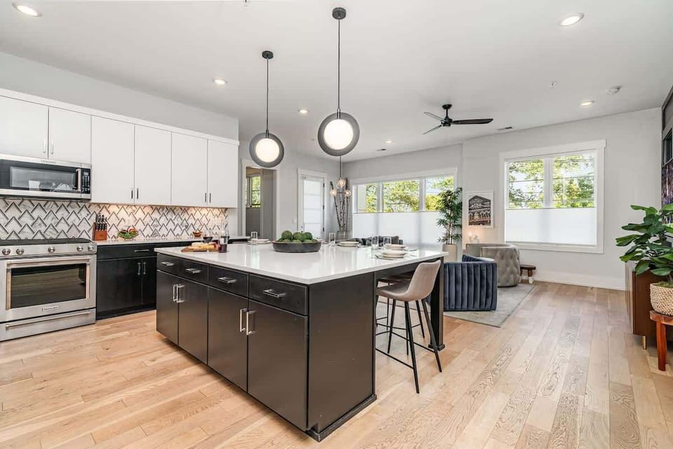 The fully equipped modern kitchen is stocked with all culinary essentials, stainless-steel appliances, and breakfast bar seating.