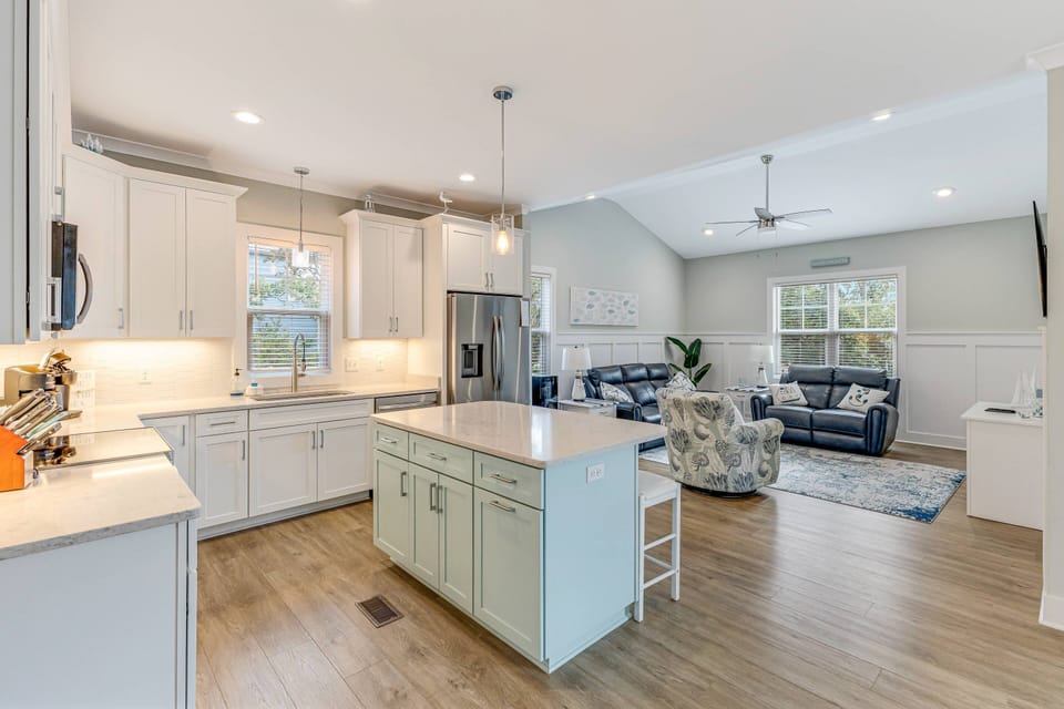 Another angle of the kitchen and a stylish breakfast island bar adjacent to the living area.