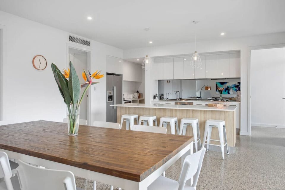 Gather around the timber dining table for easy, shared meals that flow effortlessly from kitchen to courtyard.