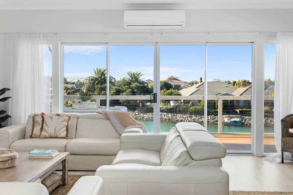 Sink into soft coastal tones and watch the lake shimmer through wide glass doors.
