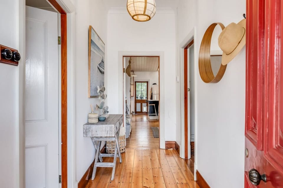Walk through the central hallway, where warm timber floors and soft light guide you gently through the home.
