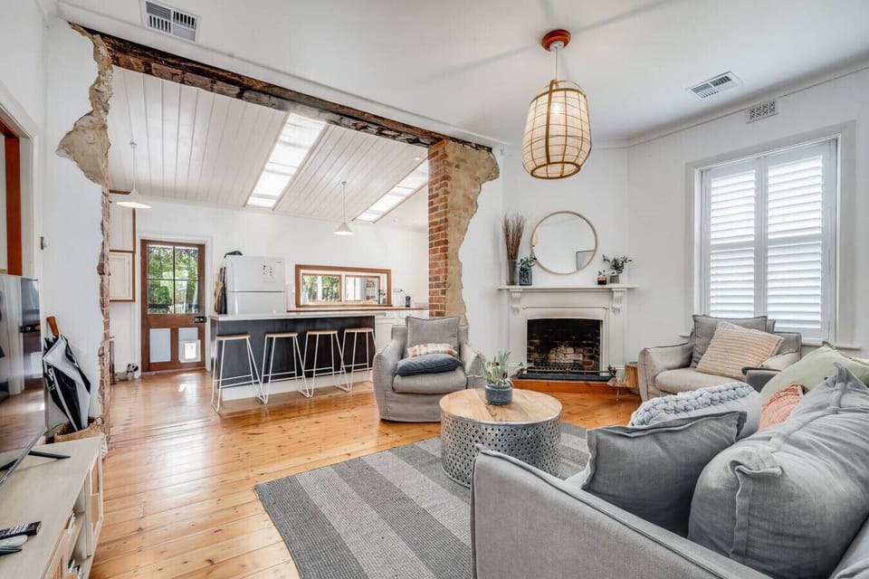 Settle into the light-filled living area, where soft seating and warm timber floors invite slow mornings and relaxed evenings together.