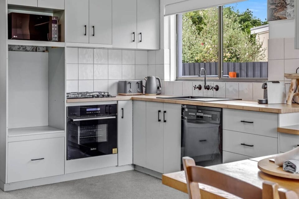 The modern kitchen features a gas stove, oven, dishwasher, and Nespresso machine, making every meal feel effortless from morning coffee to evening feasts.