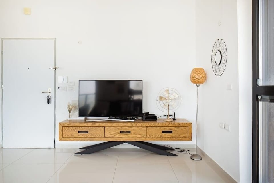 Modern TV setup creates a cozy spot for unwinding after exploring nearby restaurants and shops.