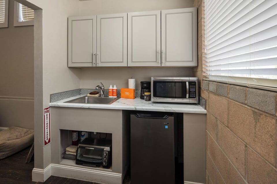 Kitchenette with a toaster, microwave, sink and mini fridge.