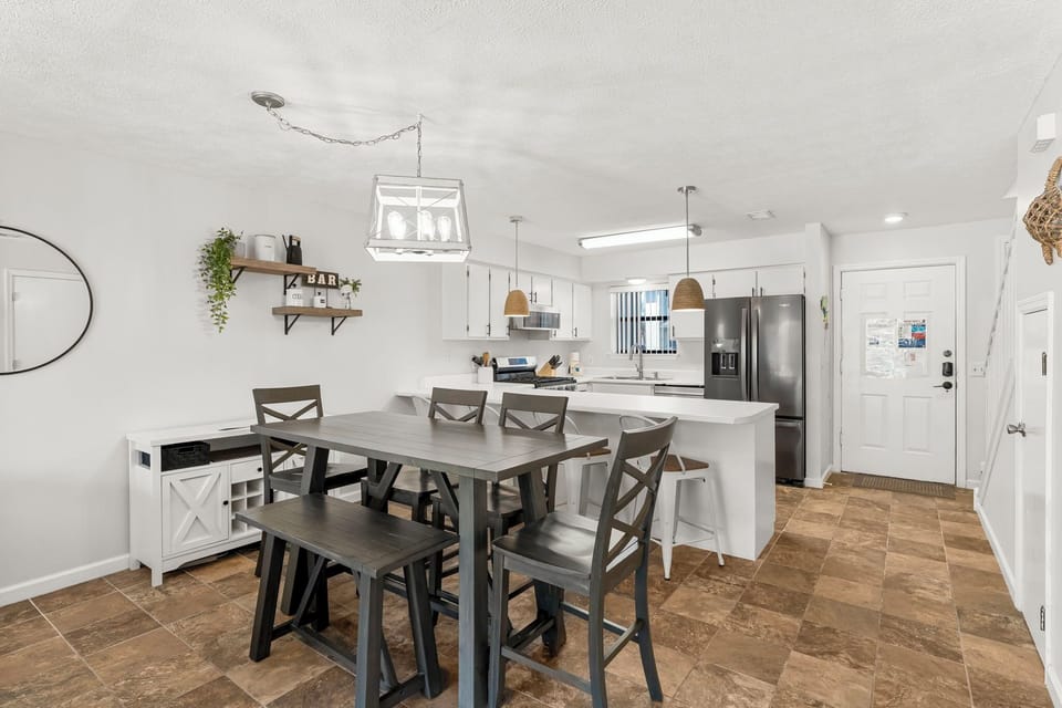 Modern kitchen and dining area with a large table and stainless steel appliances