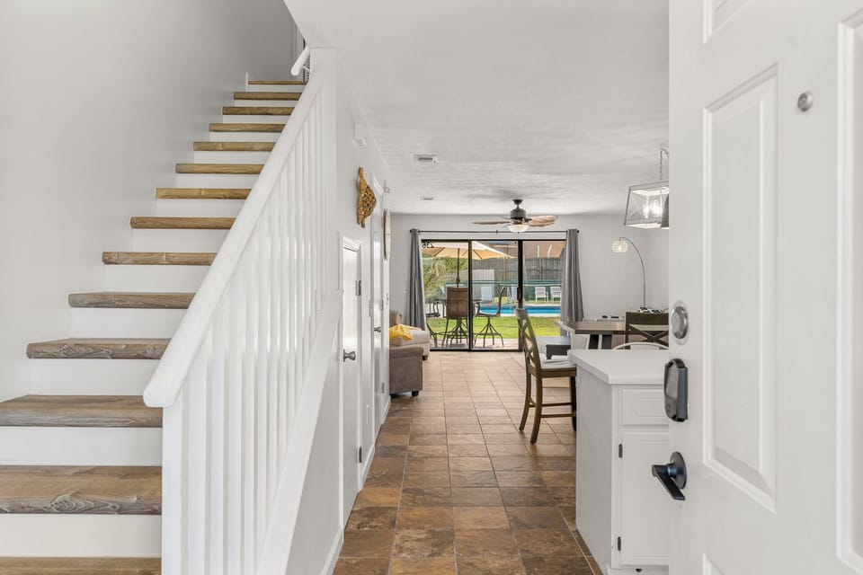Entryway leading to a bright living area with pool views and modern tile flooring