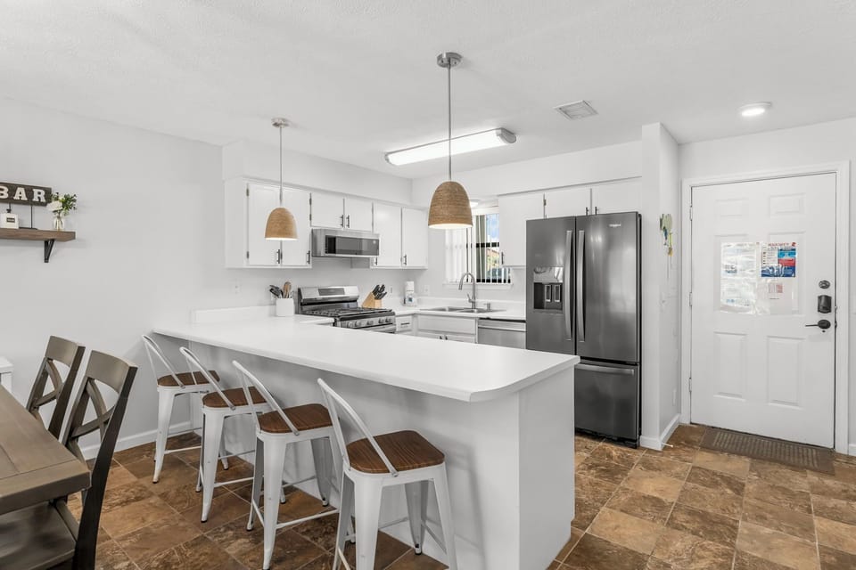 Modern kitchen with a large breakfast bar and stainless steel appliances