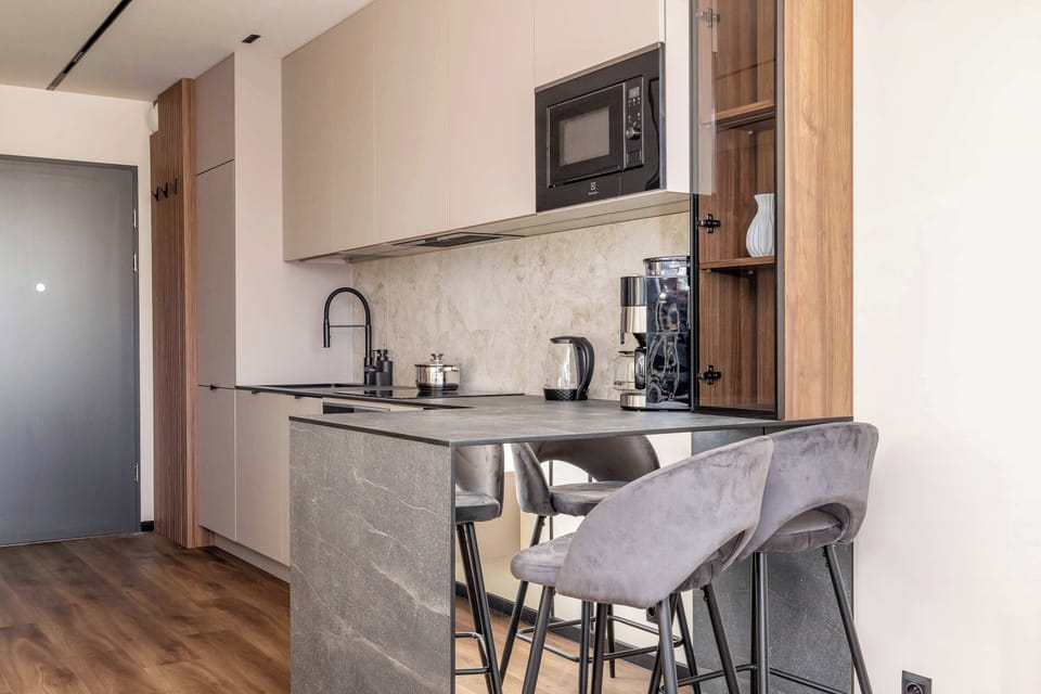 The living area features a sleek dining area and a flat-screen television.