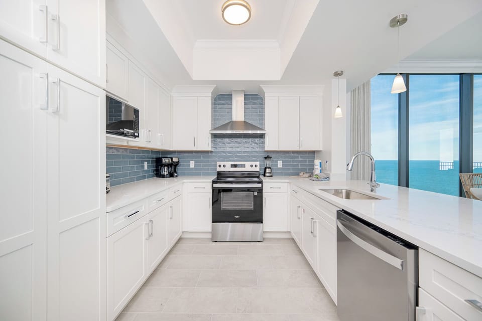 Prepare meals in this stylish kitchen, featuring stainless appliances and stunning beachfront views