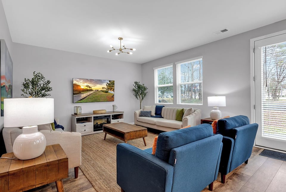 Cozy modern living room with natural light, comfy seating, and a smart TV