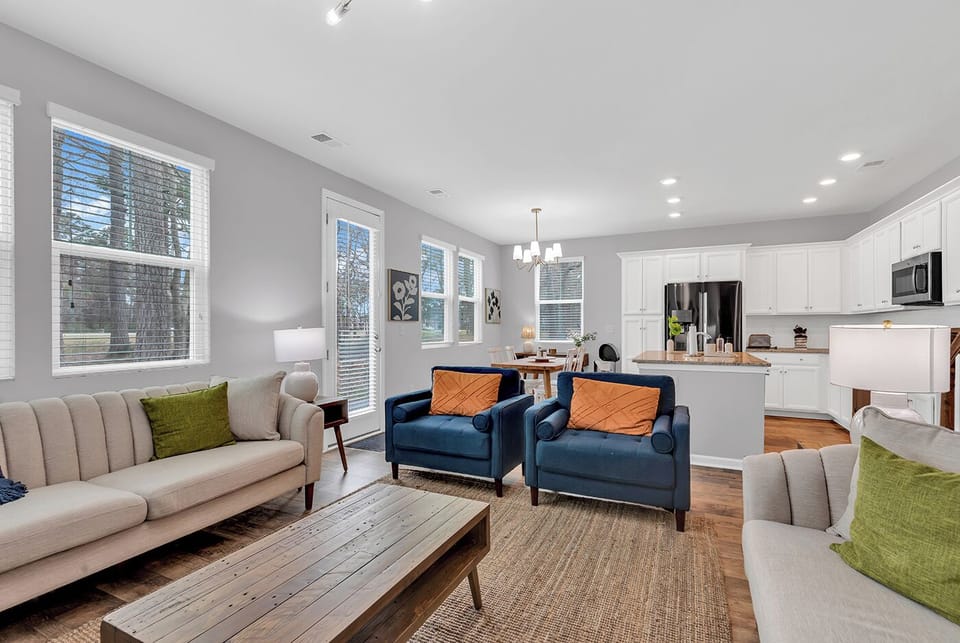 Cozy living room with natural light, comfy seating, and a smart TV for relaxing.