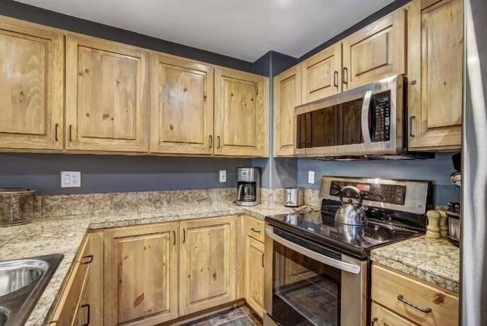 Natural wood cabinetry and sleek counters invite you to savor mountain-inspired meals, whether you’re brewing morning coffee or gathering for dinner.