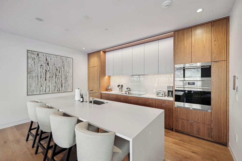 Your sleek kitchen features rich wood cabinetry, pristine countertops, and modern appliances where culinary adventures await your arrival.