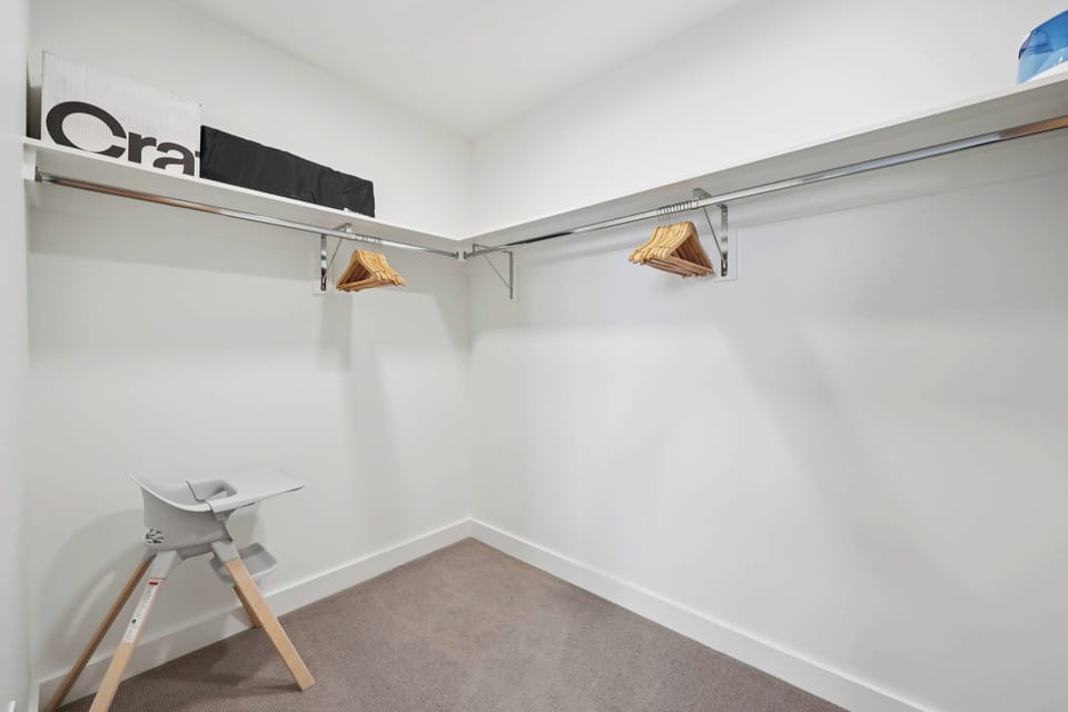 Store your belongings in this spacious walk-in closet with ample hanging space and convenient seating for dressing.