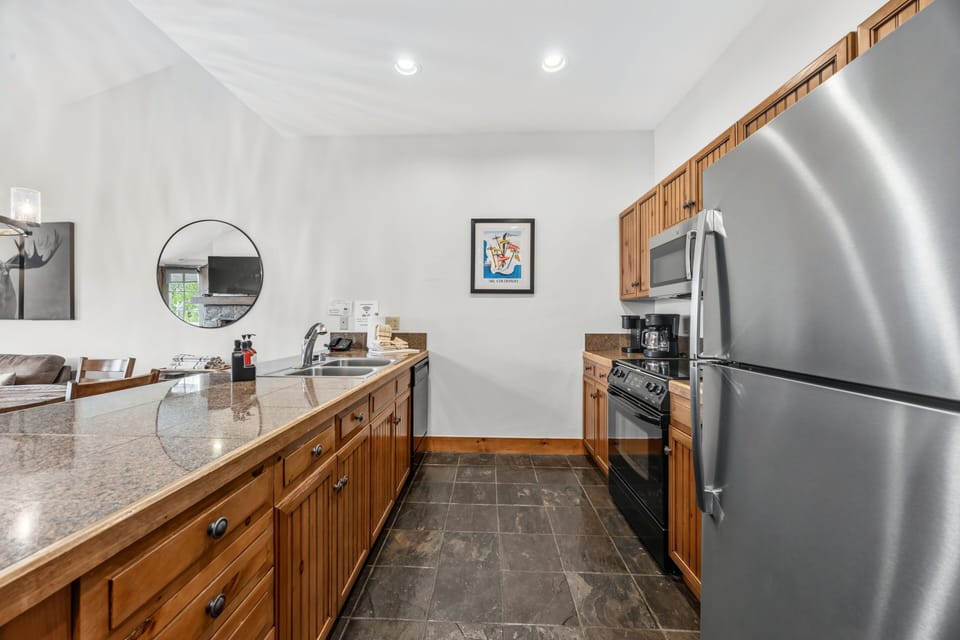 Kitchen galley — knotty pine cabinets, stainless appliances.