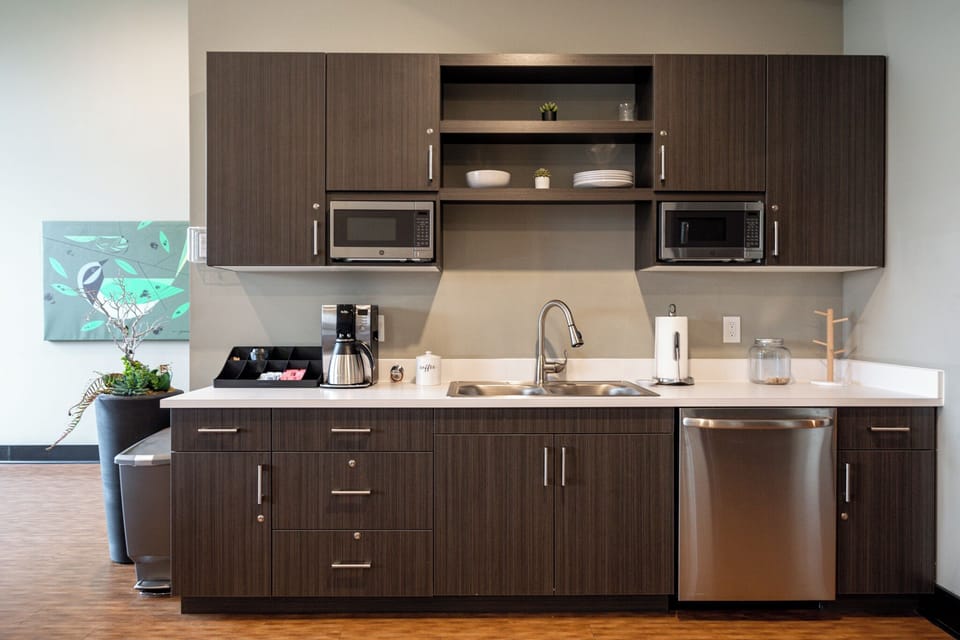 Sleek kitchen w/ dark cabinetry, stainless steel appliances, & ample counter space