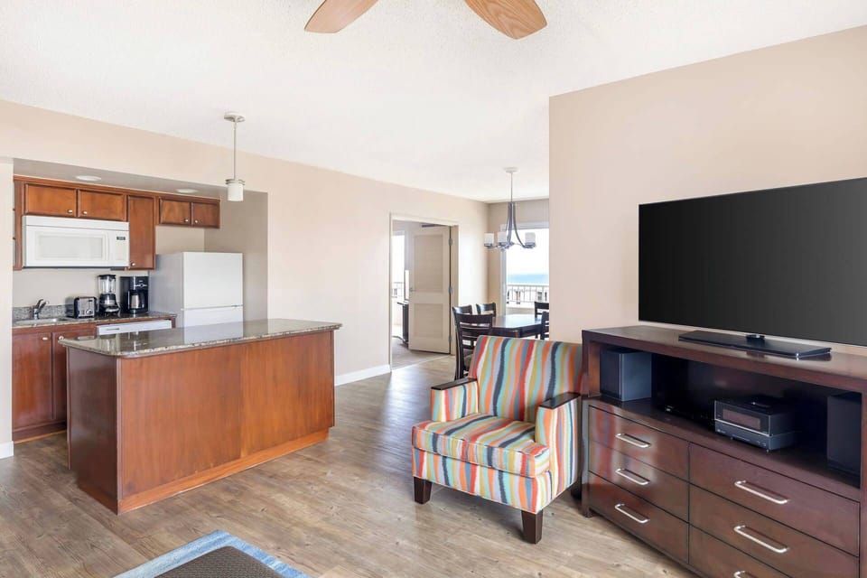 Living room has a large flat screen TV.  Separate dining area