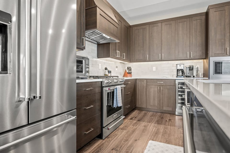 Cook with ease in a fully equipped kitchen featuring stainless steel appliances and custom cabinetry