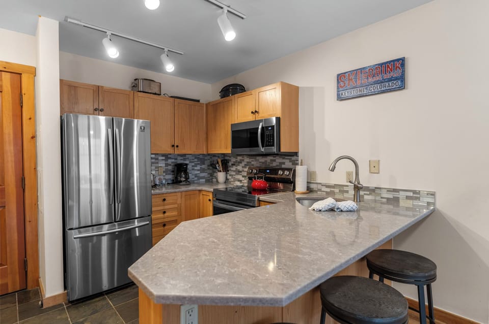 Your fully equipped kitchen awaits with granite counters, stainless appliances, and breakfast bar seating for mountain meal prep.
