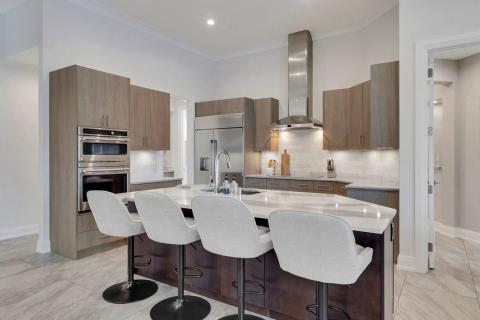 The eating island with barstool seating defines the kitchen space, which is highlighted by luxury finishes and appointments.