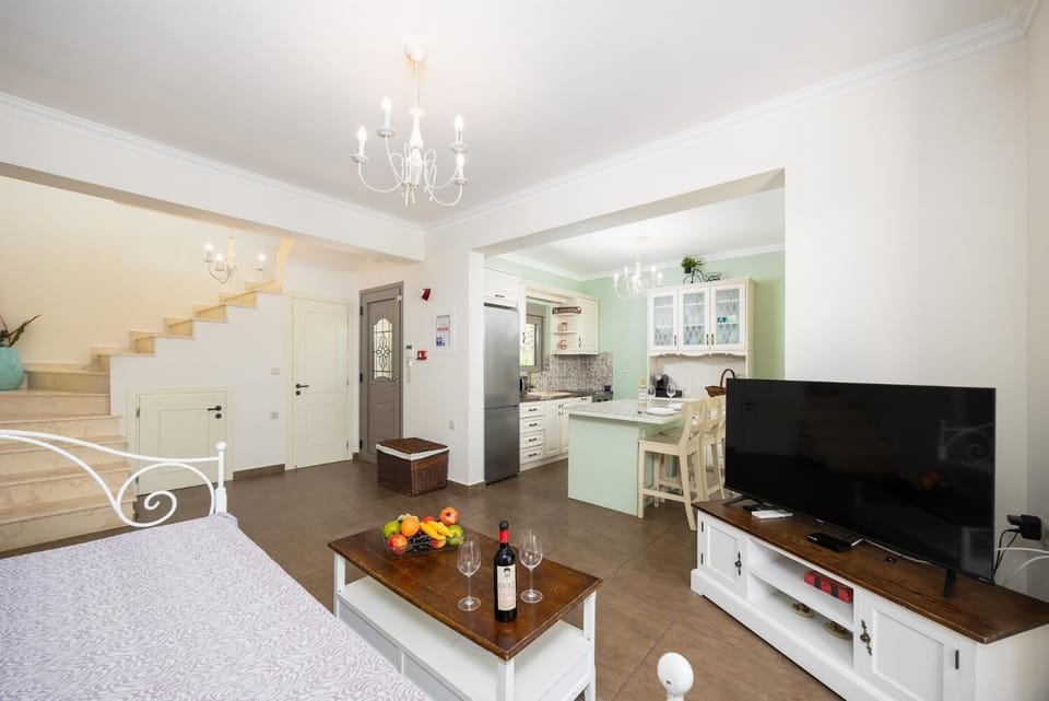 Open-plan living room with sofa, breakfast bar, kitchen, A/C, WiFi internet, and satellite TV