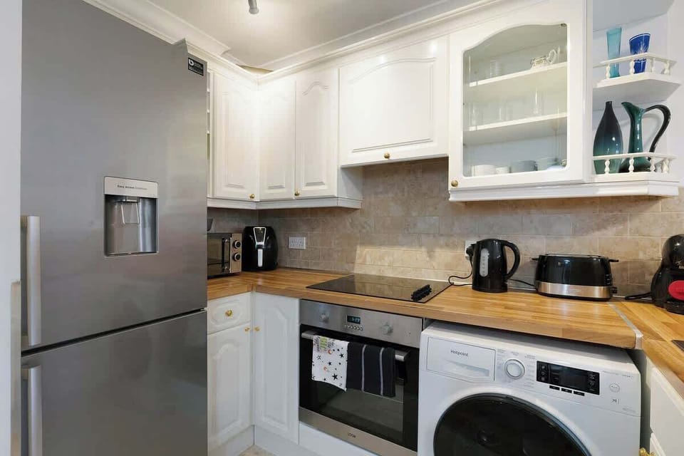 Kitchen equipped with all essentials, including a washer & dryer, oven, fridge and full cookware set.