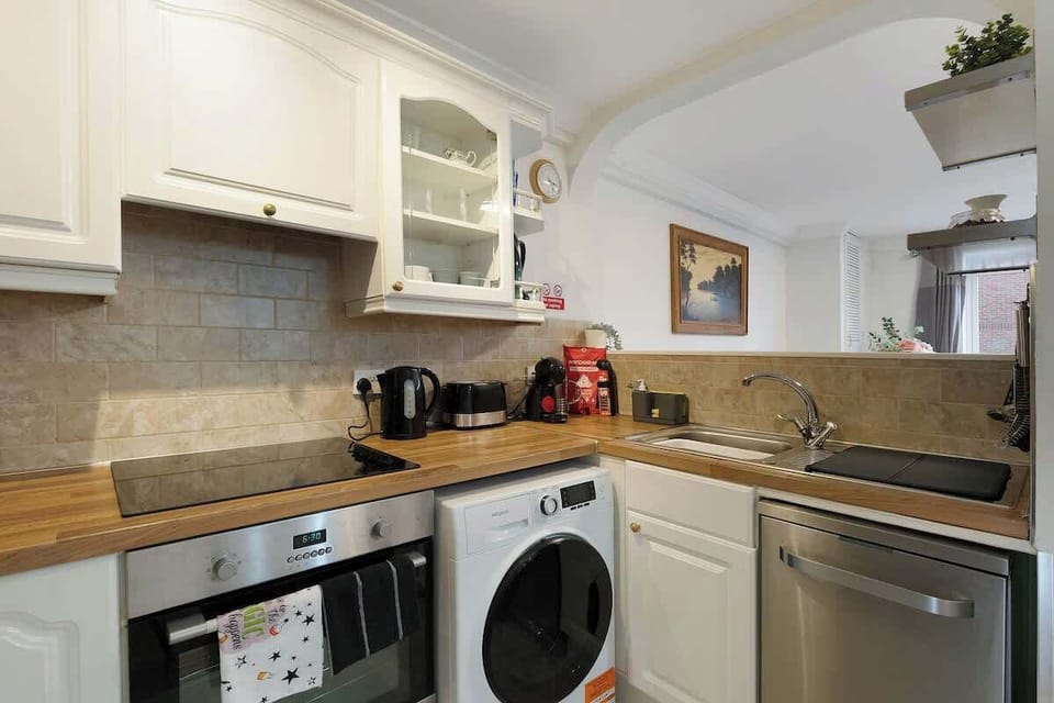Kitchen equipped with all essentials, including a washer & dryer, oven, fridge and full cookware set.