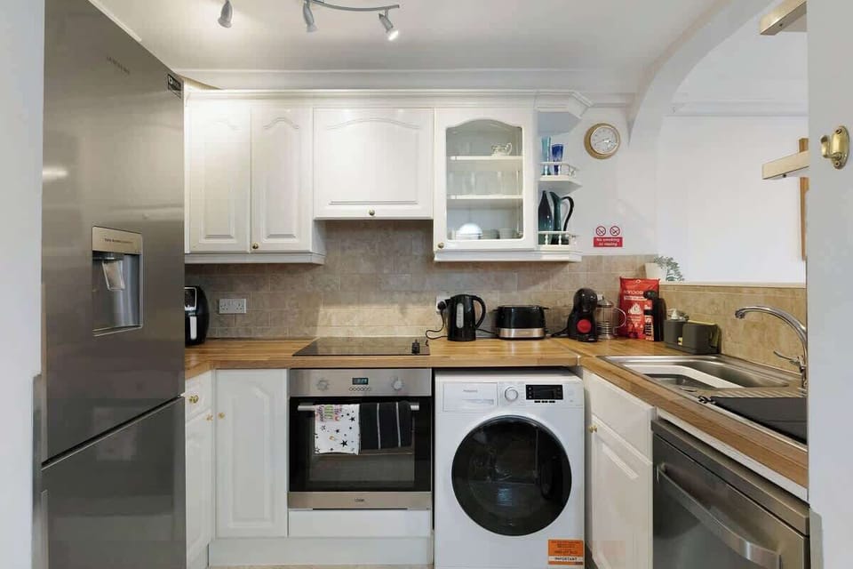 Kitchen equipped with all essentials, including a washer & dryer, oven, fridge and full cookware set.