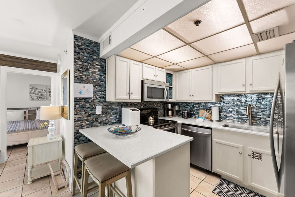 Bright, fully equipped kitchen with stainless-steel appliances and beautiful blue glass backsplash