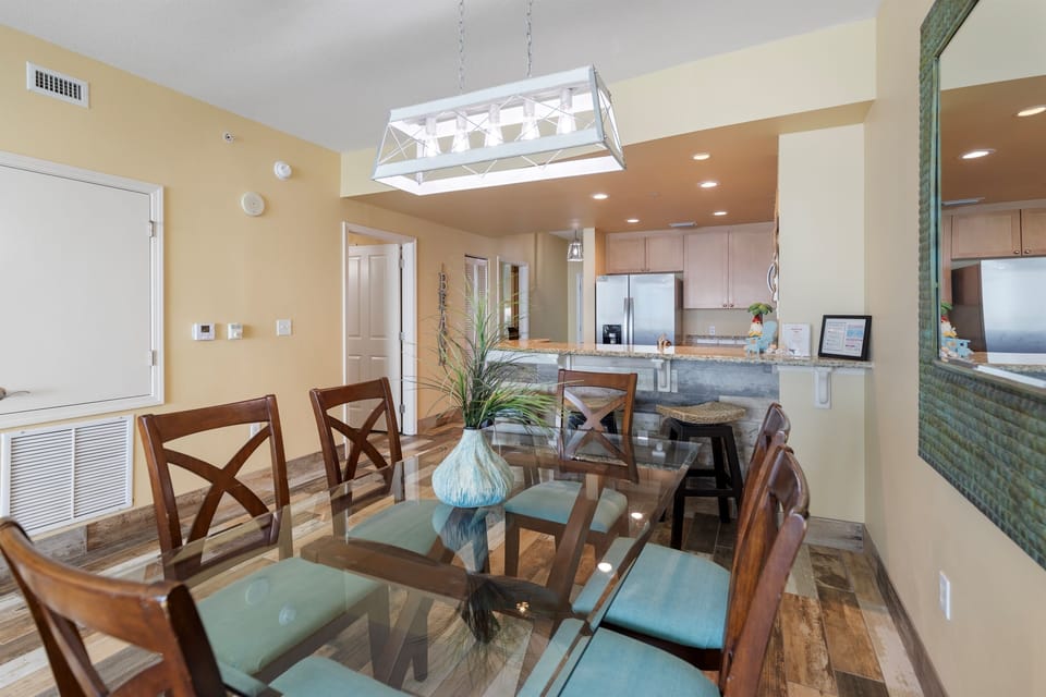 Gather around your elegant glass dining table for memorable meals in this bright, open-concept space that flows seamlessly into the fully-equipped kitchen.