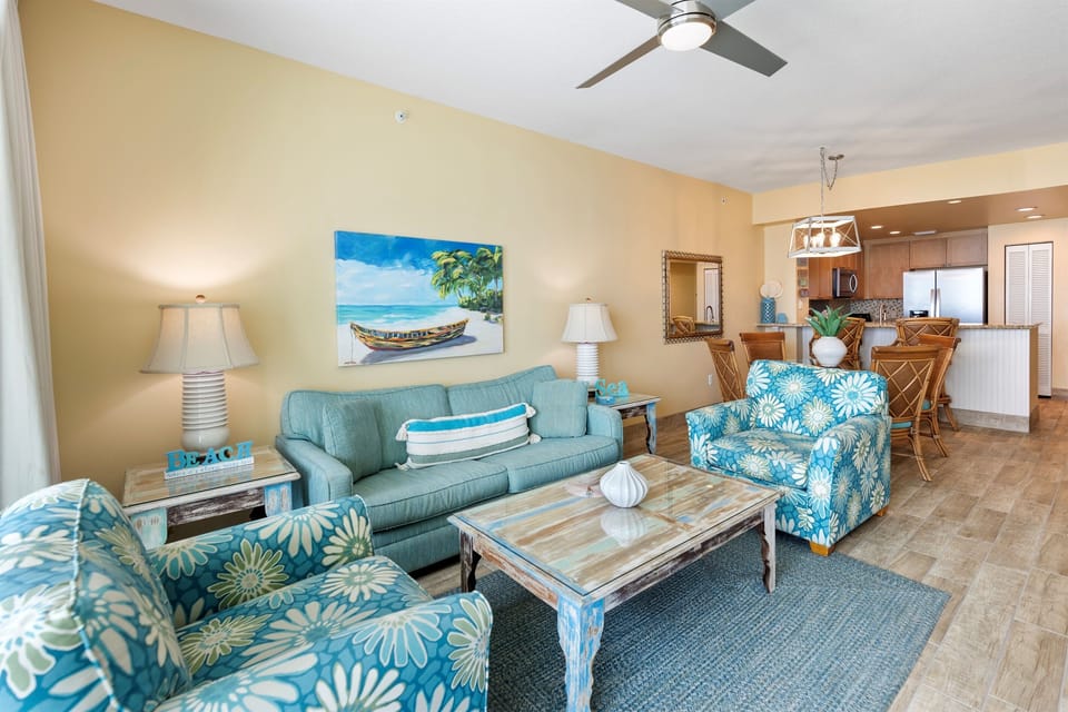 Sink into tropical-style seating where coastal blues meet warm comfort, all under your ceiling fan's gentle breeze.