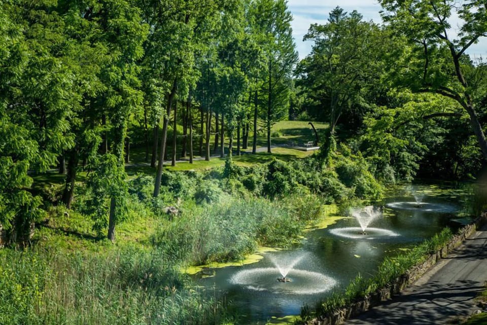 Lush gardens surround tranquil ponds, with sparkling fountains providing a serene backdrop for leisurely strolls along the peaceful walking trails.