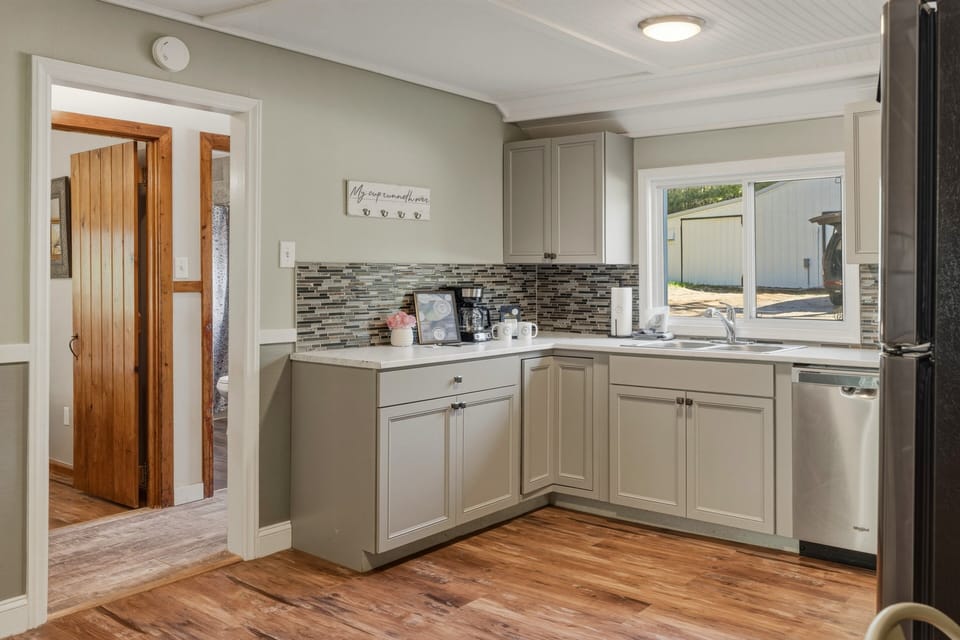 Bright updated kitchen with modern cabinets, coffee essentials, stainless steel appliances, and plenty of space for easy meals during your stay.