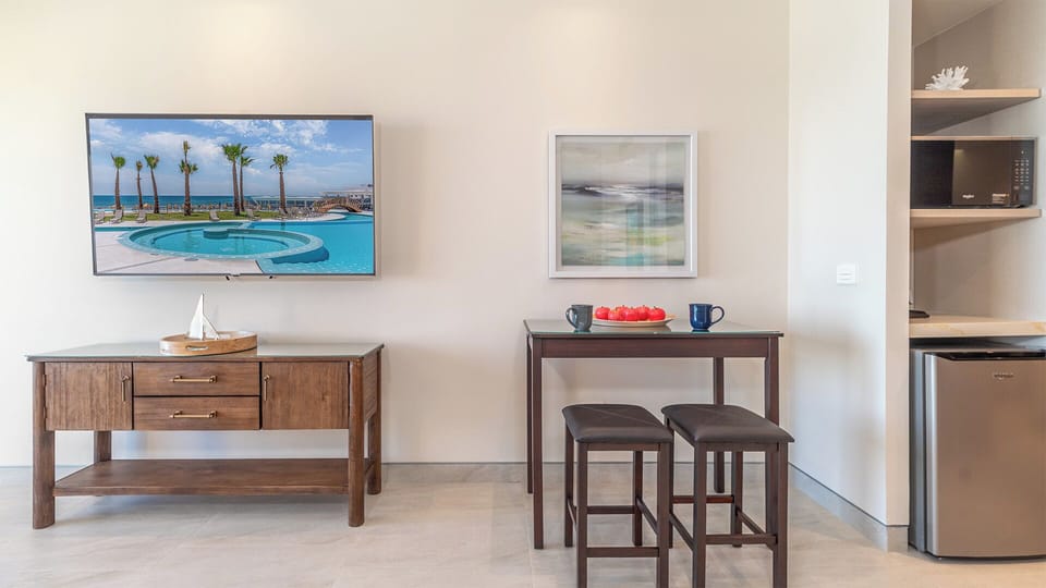 TV, entertainment center, raised table and the kitchenette space.