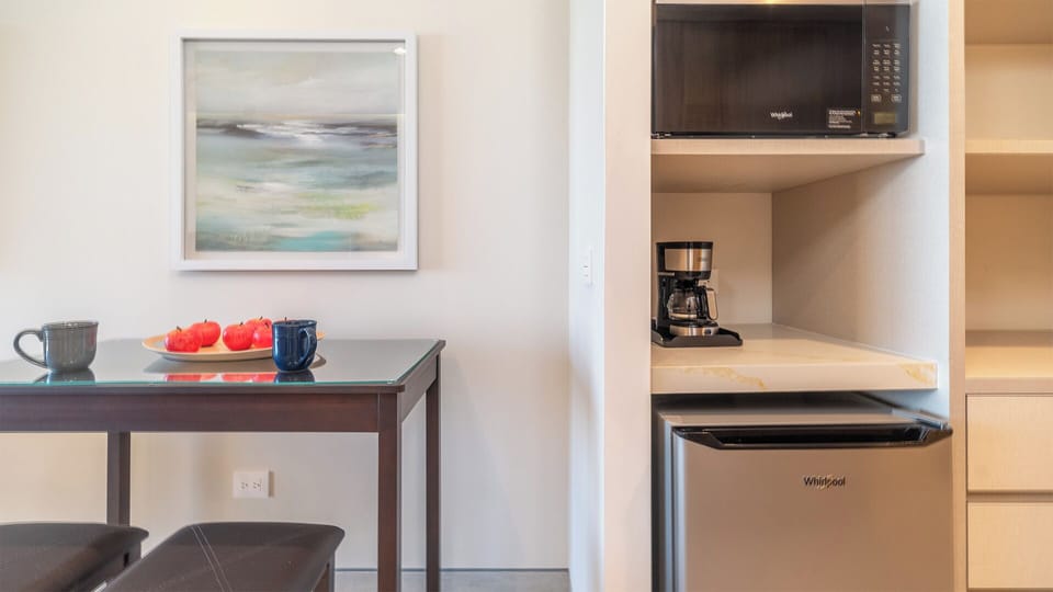 The table for two, and the refrigerator, coffee maker, and microwave oven.