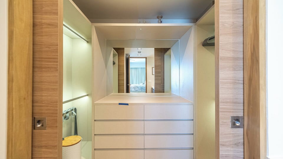 The large walk-in closet with lots of shelves and lighted rods