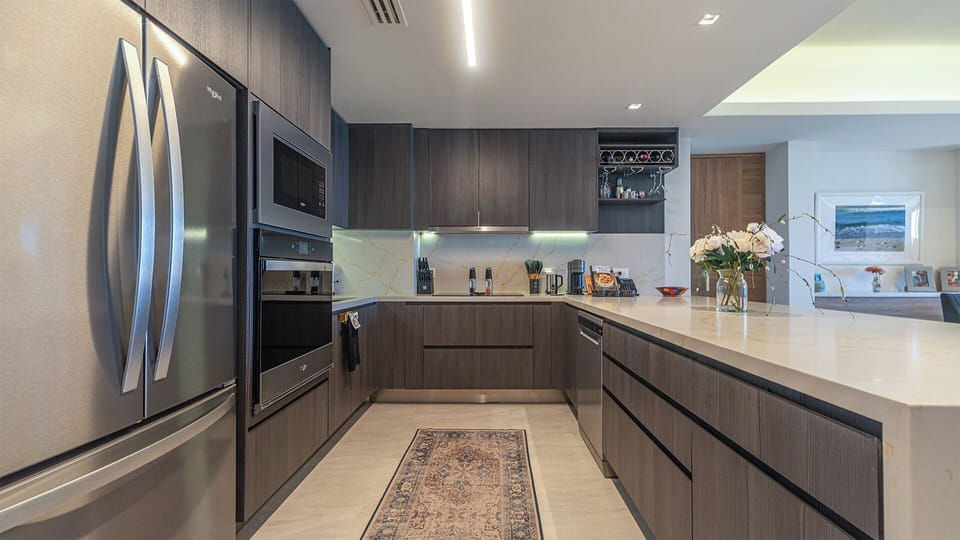 The kitchen with stainless steel appliances and sleek, modern cabinetry
