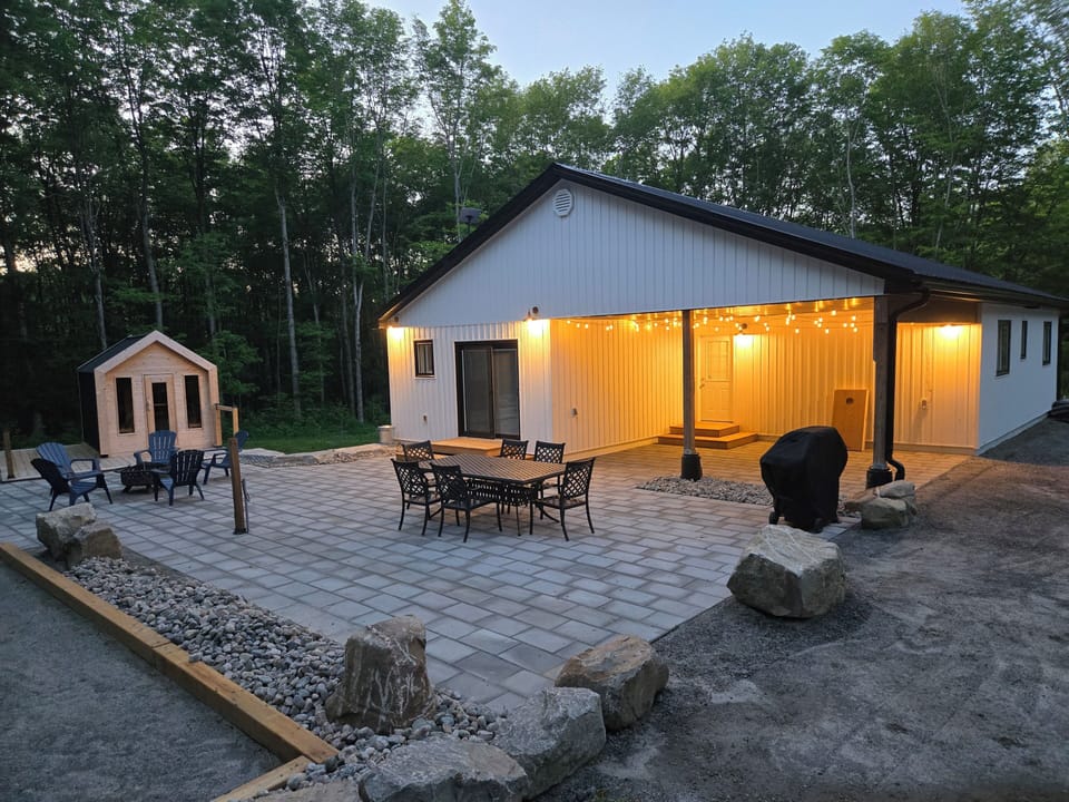 back patio with dining table, carport, fire pit,sauna and bocce court 