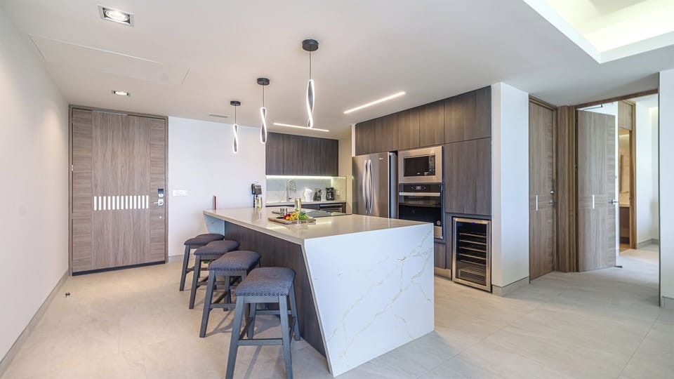 Bright, airy kitchen designed for comfort and functionality. Cook up meals on the large island, prep with ease in the generous sink area, and make use of stainless-steel appliances. Plenty of space for dining, chatting, and enjoying ocean views just beyond the windows.