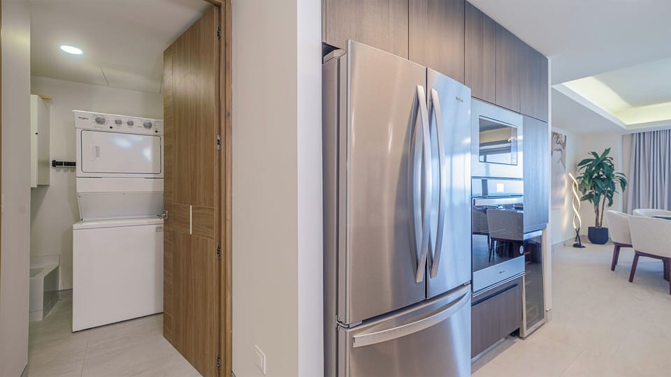 Fully equipped kitchen featuring sleek stainless-steel appliances, plus the convenience of an in-unit washer and dryer