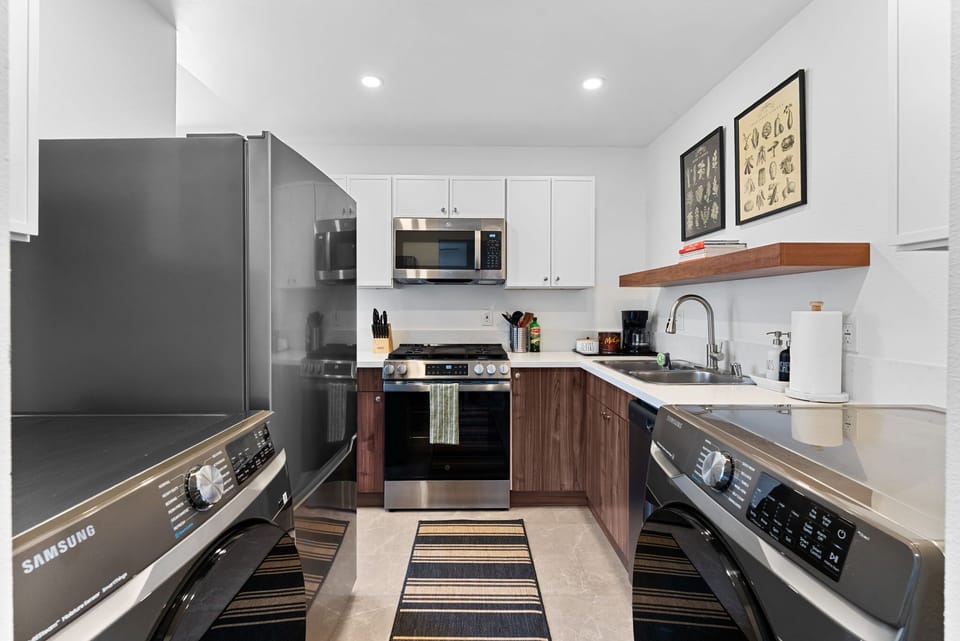 A sleek kitchen will walnut cabinets and stainless steel appliances.