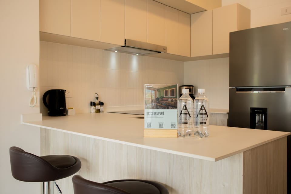 Kitchen area with wooden cabinets and bar seating.