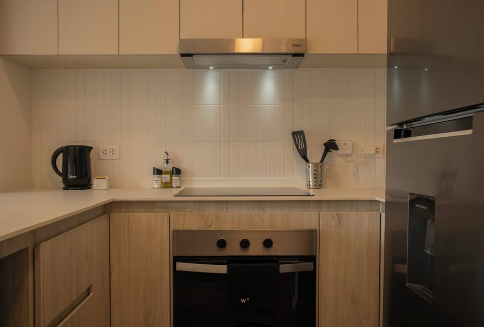 Modern kitchen with hood and built-in appliances.