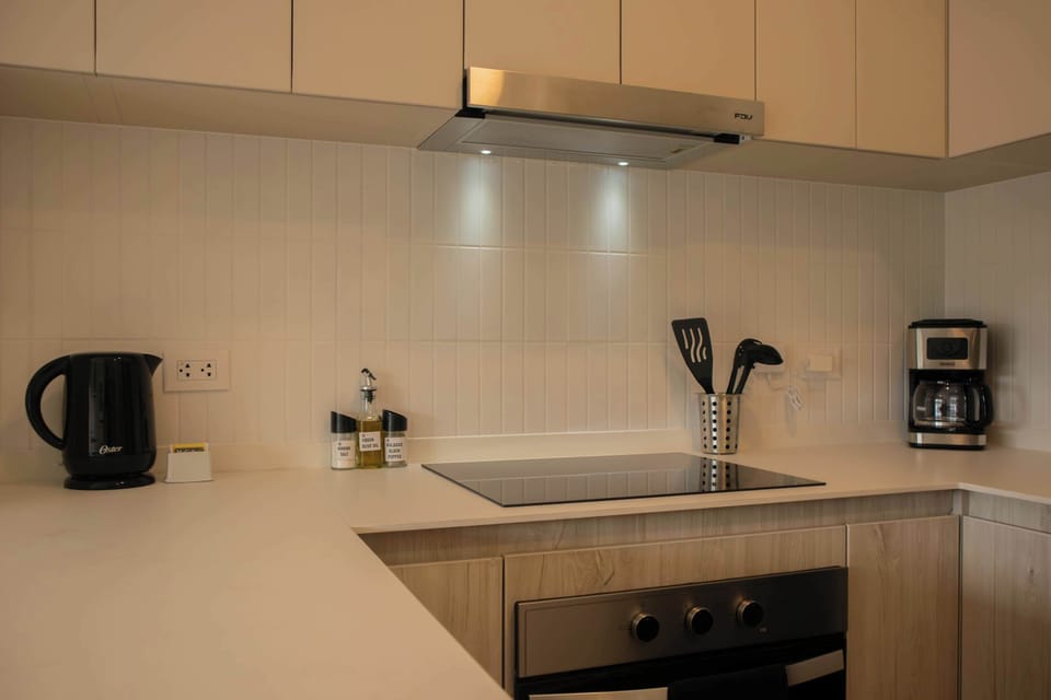 Kitchenette with small appliances and wood cabinetry.