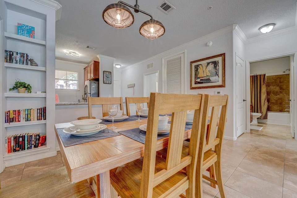 Dining area with wooden table and seating for six in a bright, open layout.